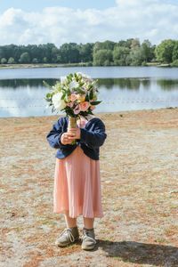 Bruidsmeisje kindje met bloemen voor gezicht