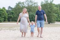 ouders wandelend met kind op zandvlakte